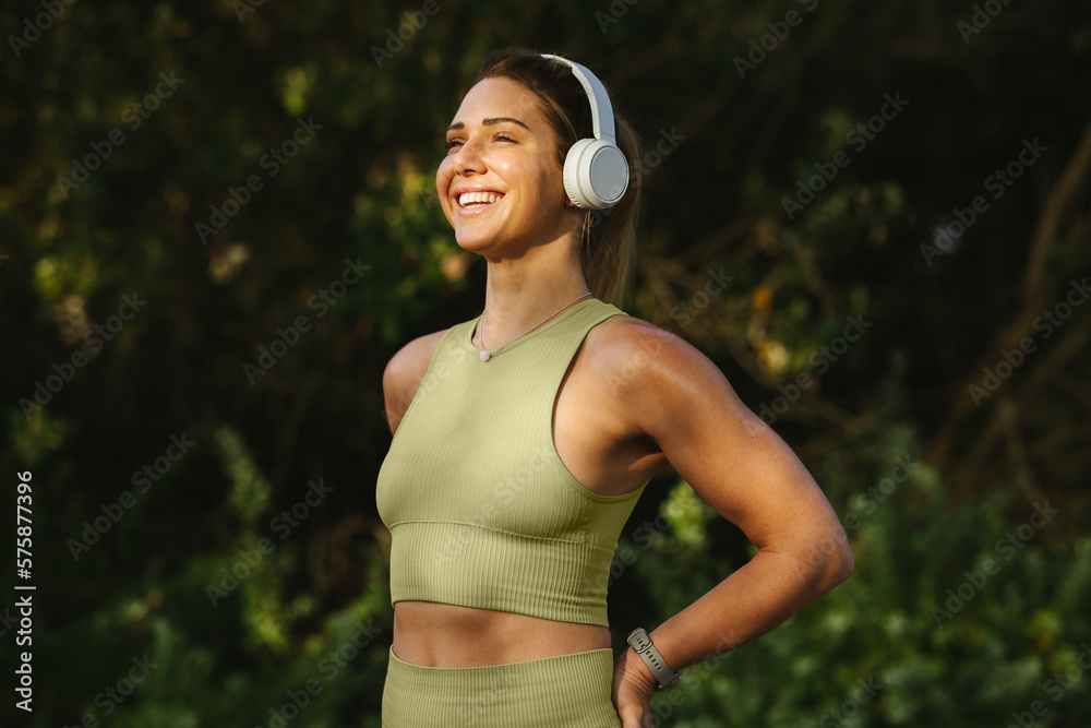 Sports woman listening to a warmup playlist before a workout outdoors