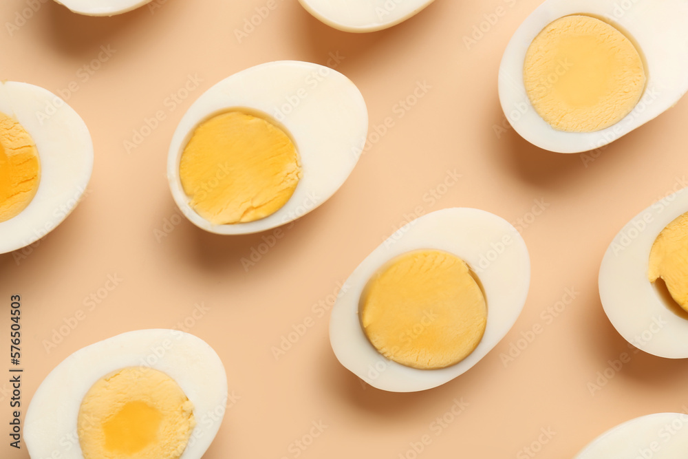 Many halves of delicious boiled eggs on beige background