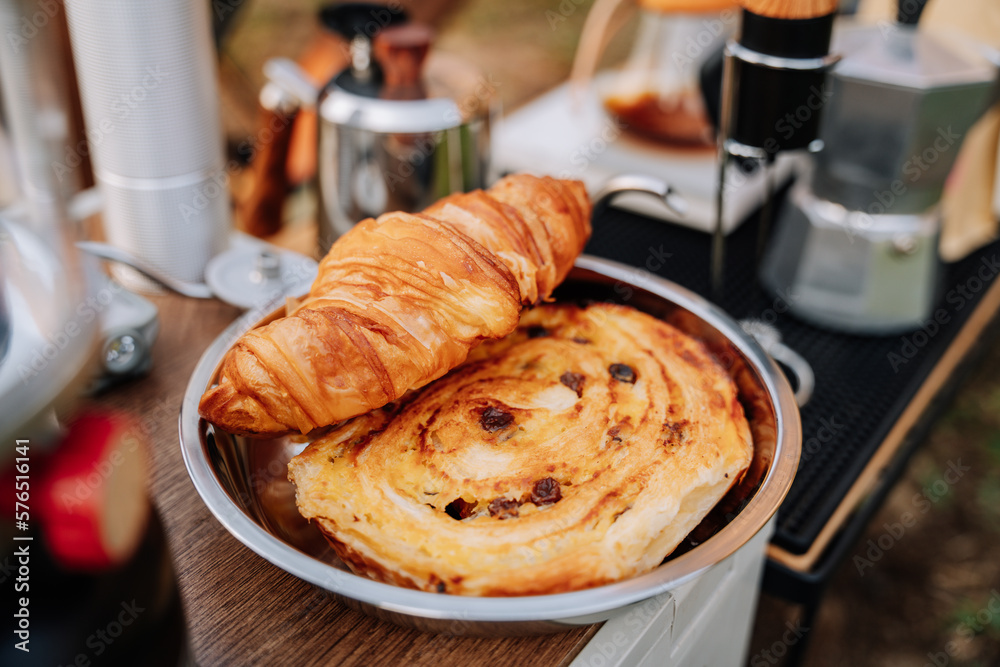 Croissants on stainless steel plate for camping. French tasty picnic. Strawberry pile. Summer Campin