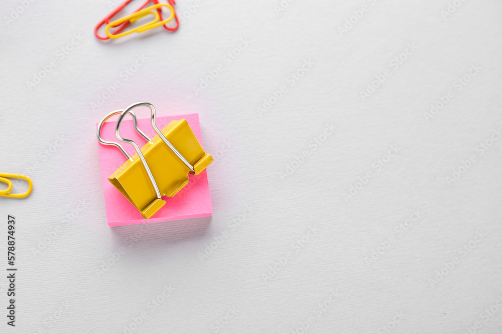 Binder clip and sticky notes on grey background