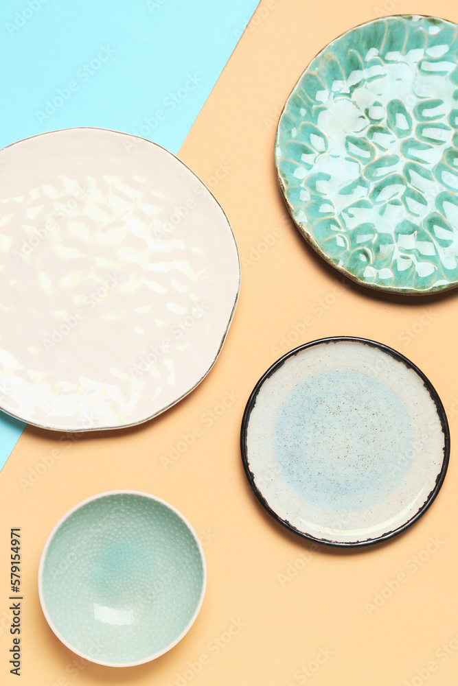 Composition with clean ceramic plates on blue and beige background
