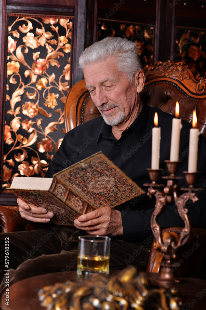 portrait of old man with book at home