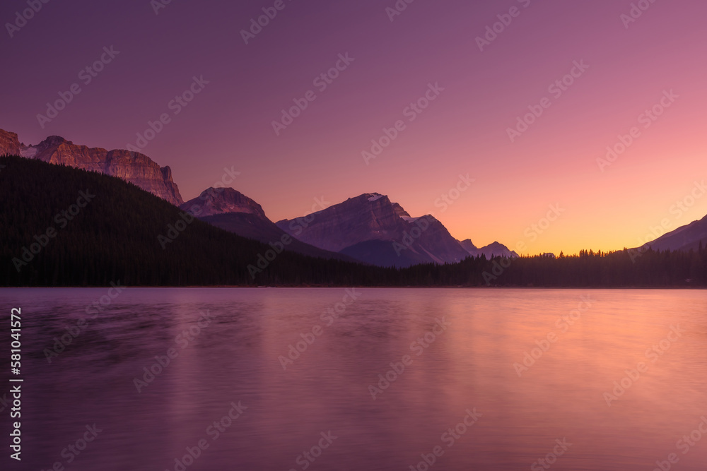 Lake and mountains in a valley at dawn. Reflections on the surface of the lake. Mountain landscape a