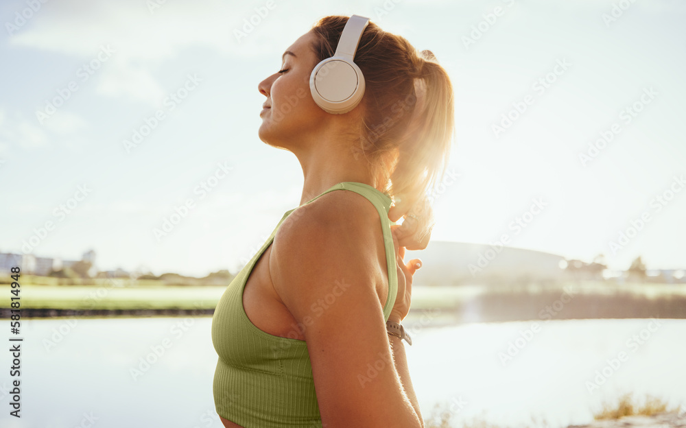 Woman in her 30s prepares to start her exercise routine on a sunny summer day