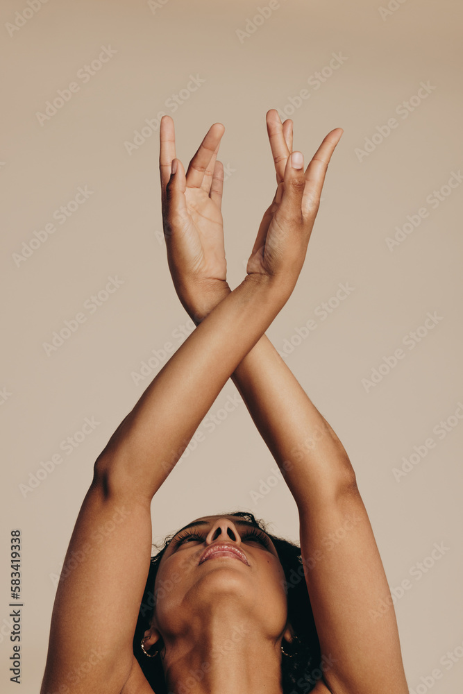 Young woman dancing and expressing herself with her arms raised
