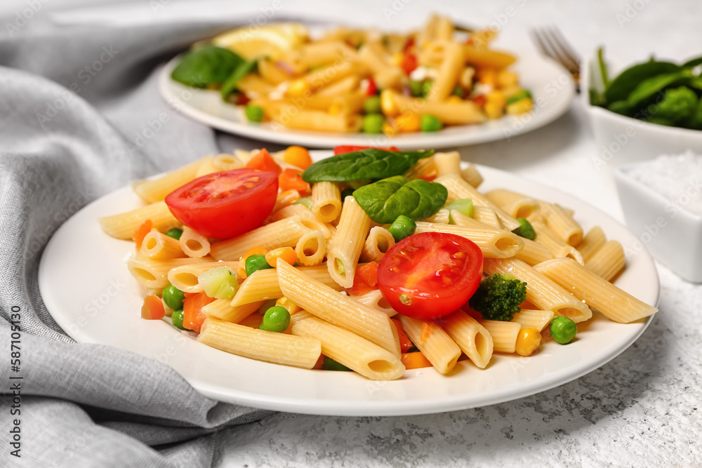 Plates with tasty pasta salad on light background, closeup