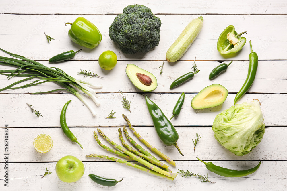 Composition with different fresh green vegetables on white wooden background