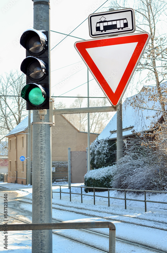 View of traffic lights with signs in city on winter day