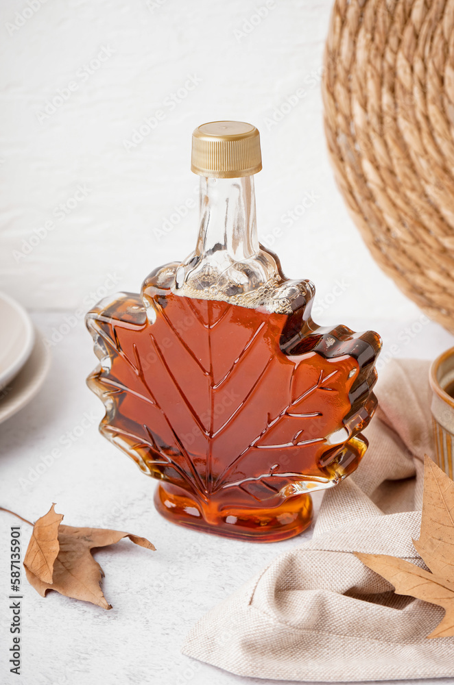 Beautiful composition with bottle of maple on white background