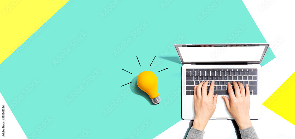 Person using a laptop computer and a light bulb - Flat lay