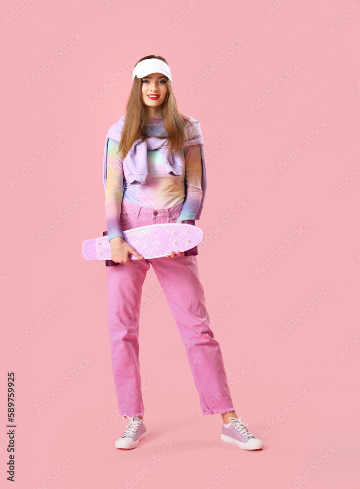 Stylish young woman with skateboard on pink background
