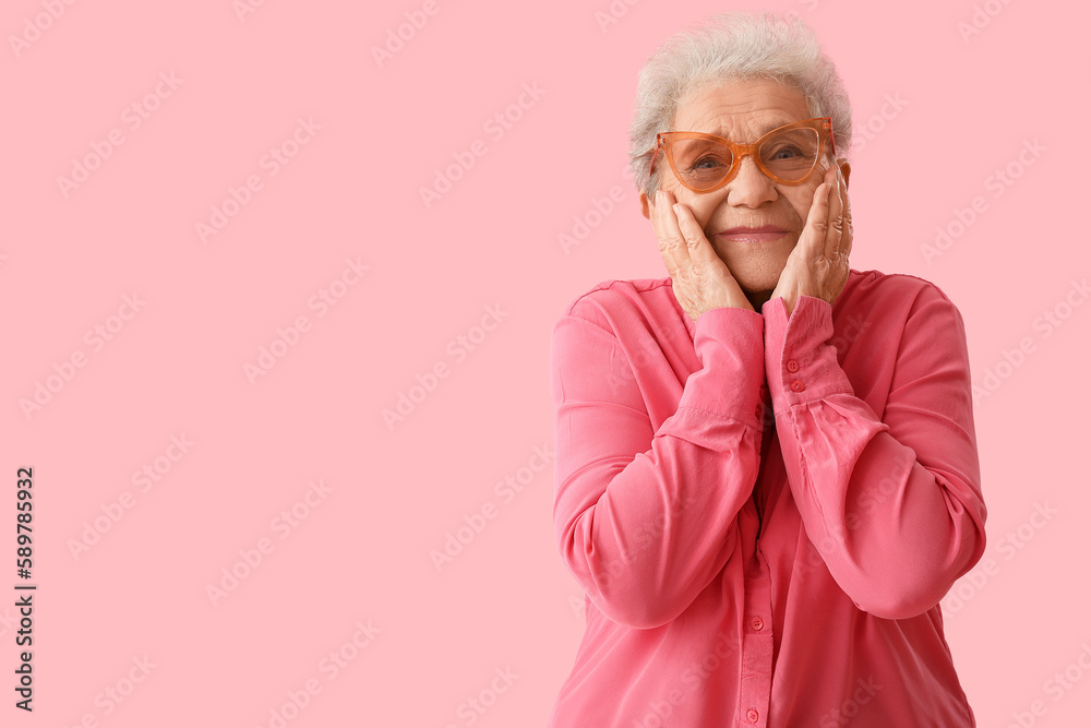 Happy senior woman on pink background