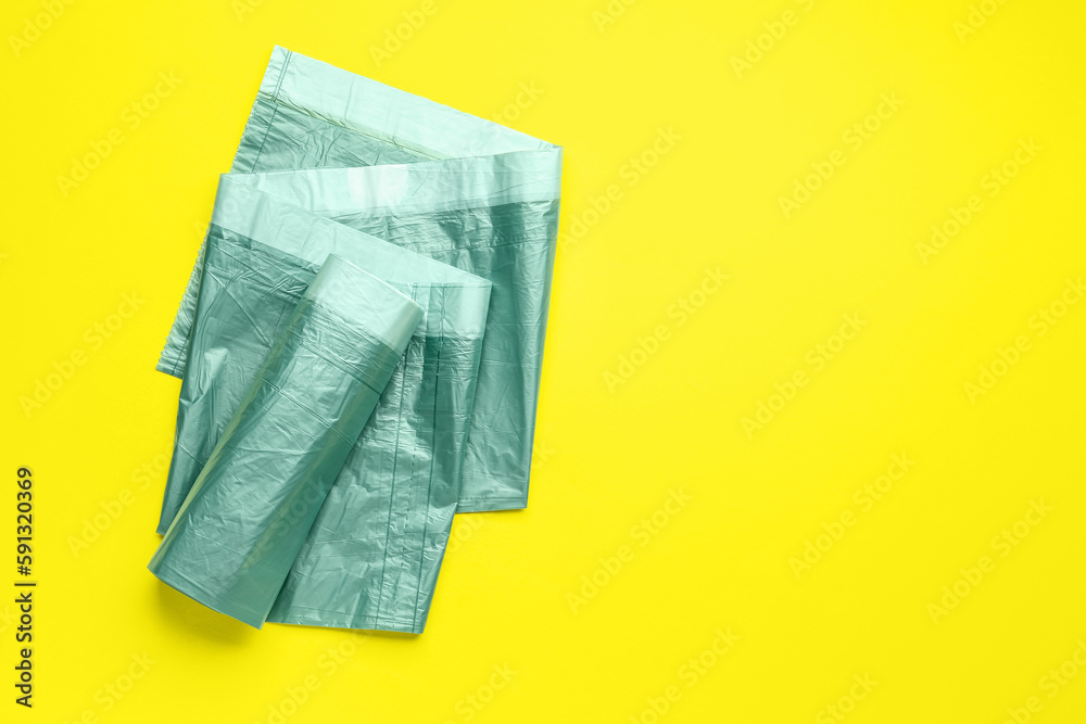 Roll of garbage bags on yellow background