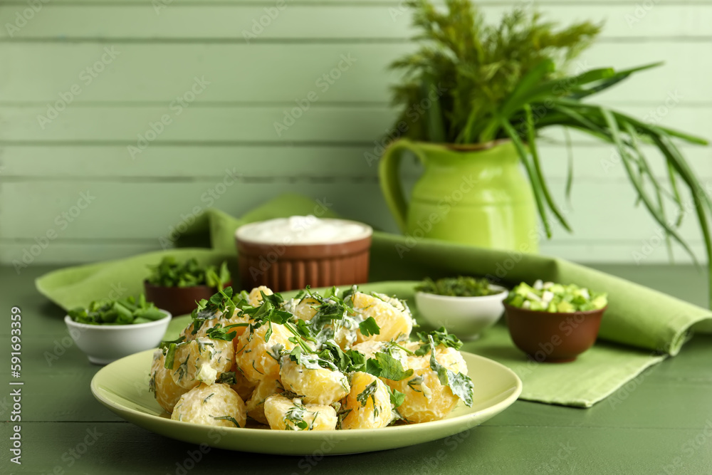 Plate of tasty Potato Salad with greens on table