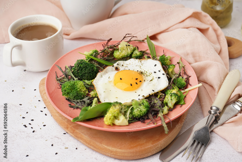 Plate with tasty fried egg and salad on light background
