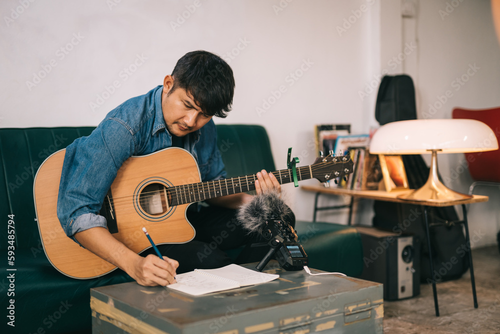 Asian songwriter or composer composing sheet music writing on paper Professional songwriter with aud