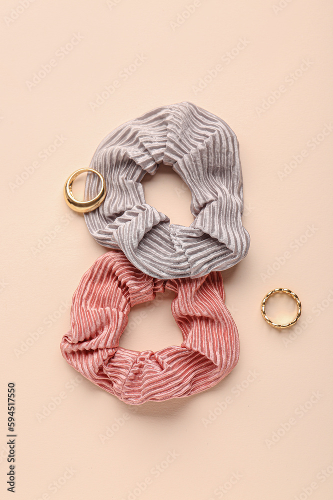 Stylish scrunchies and rings on color background