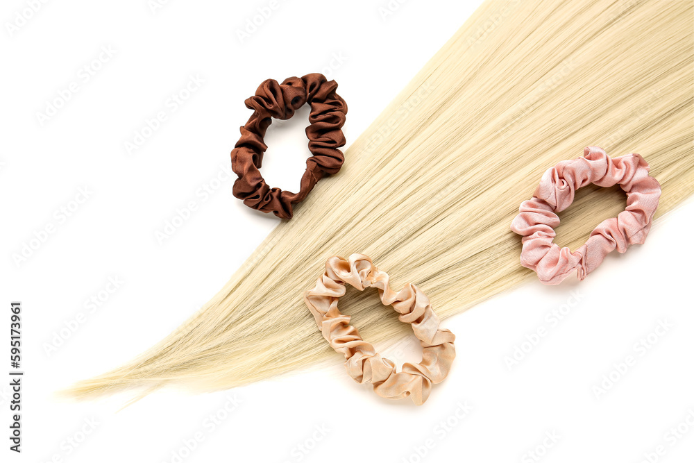 Hair strand and scrunchies on white background, closeup