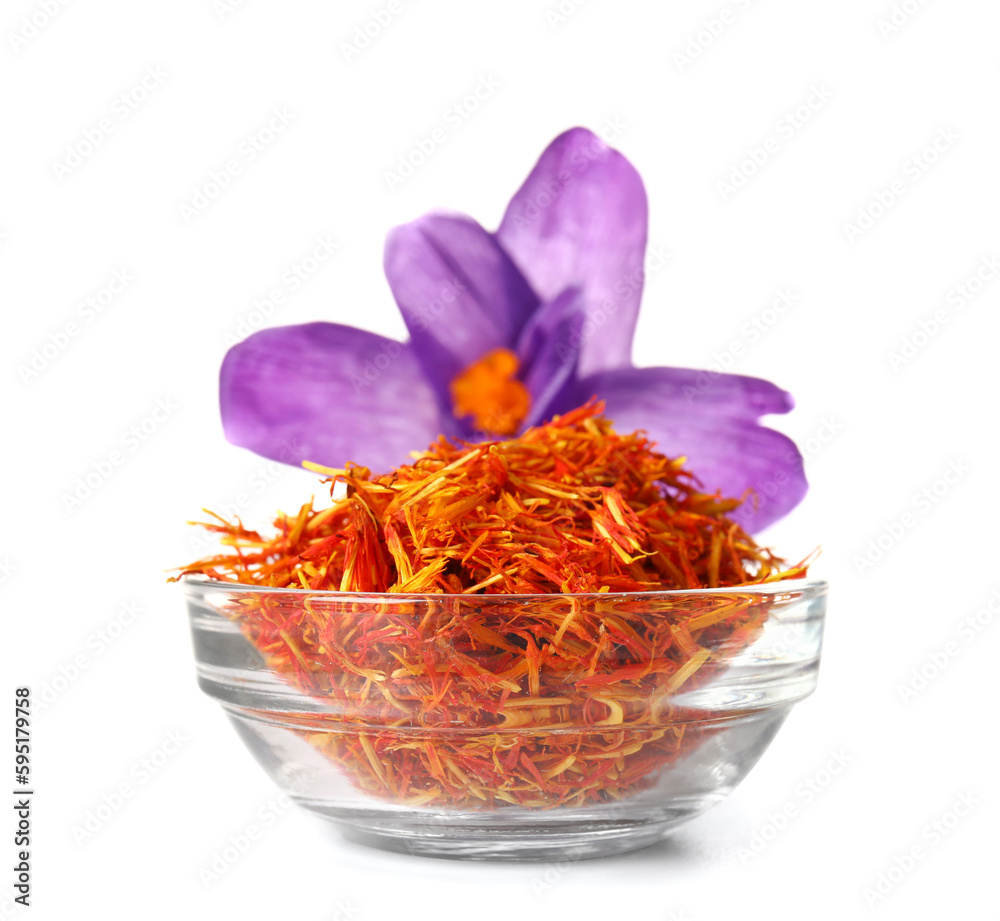 Bowl of dried saffron threads and crocus flower isolated on white background