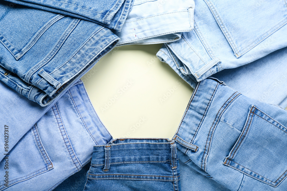 Frame made of stylish jeans on beige background, closeup