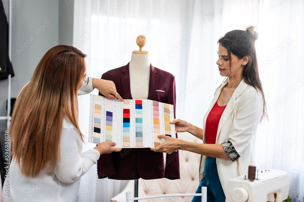 Diverse women fashion designer work design clothes in tailoring atelier. 