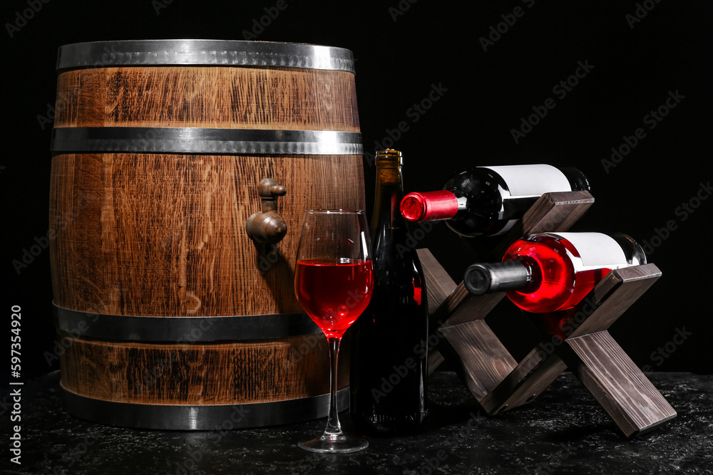 Wooden barrel, stand with bottles and glass of wine on dark background