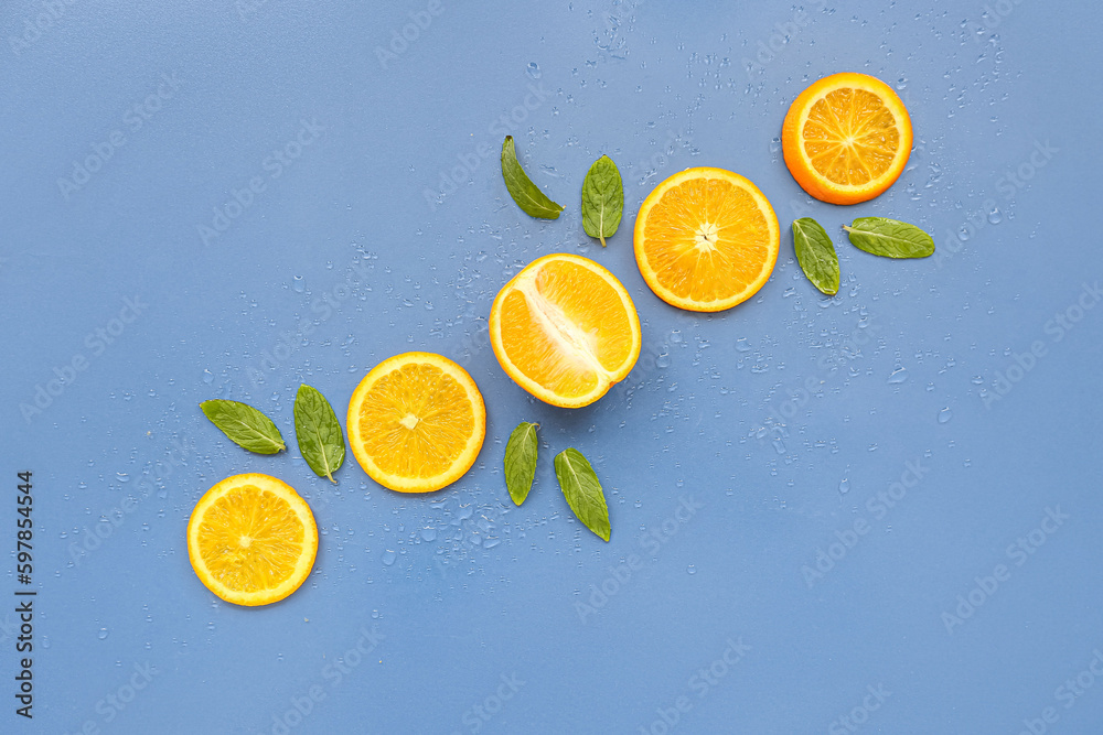 Orange slices and mint on blue background