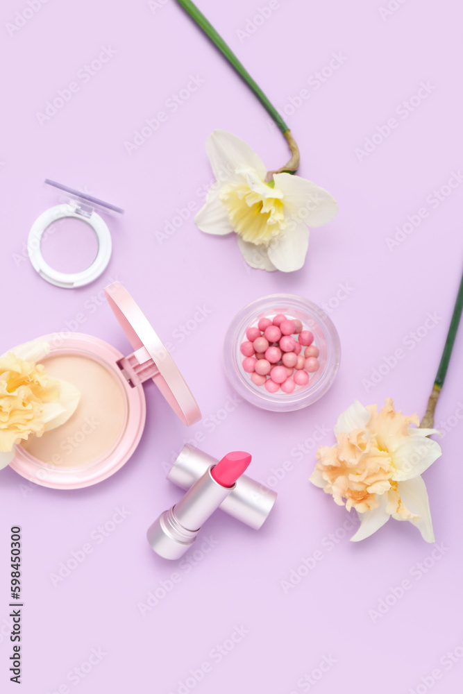 Beautiful daffodils with different cosmetics on lilac background