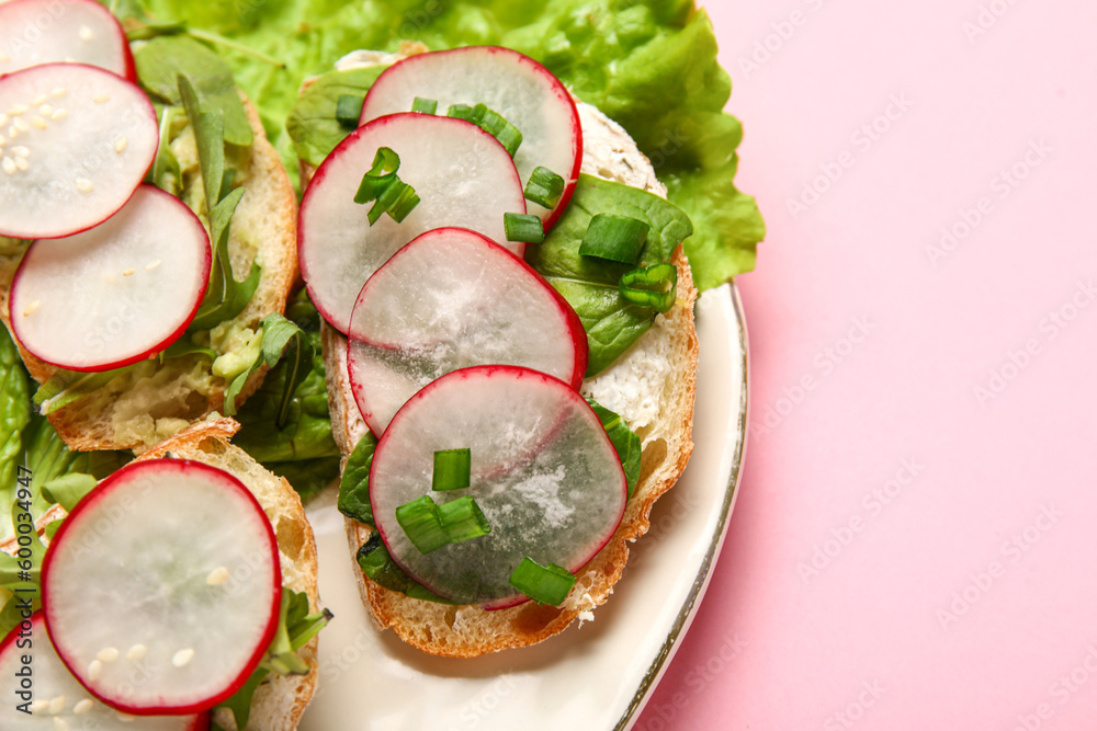 Plate with delicious radish bruschettas on pink background