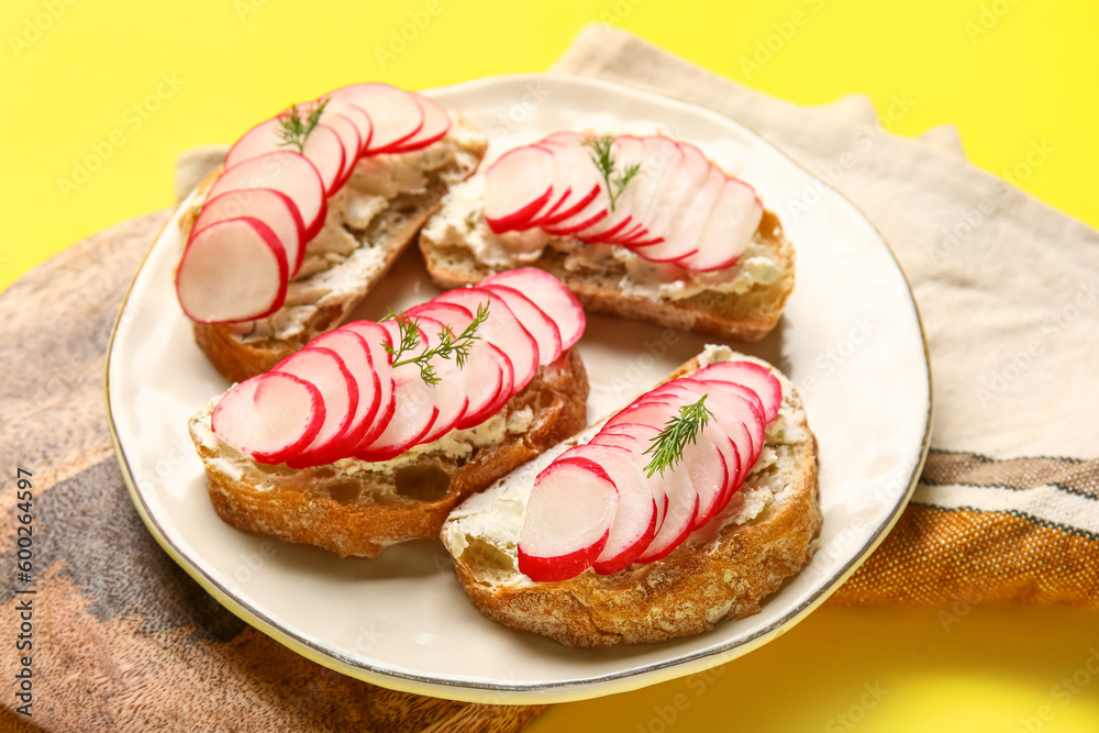 Plate with delicious radish bruschettas on yellow background
