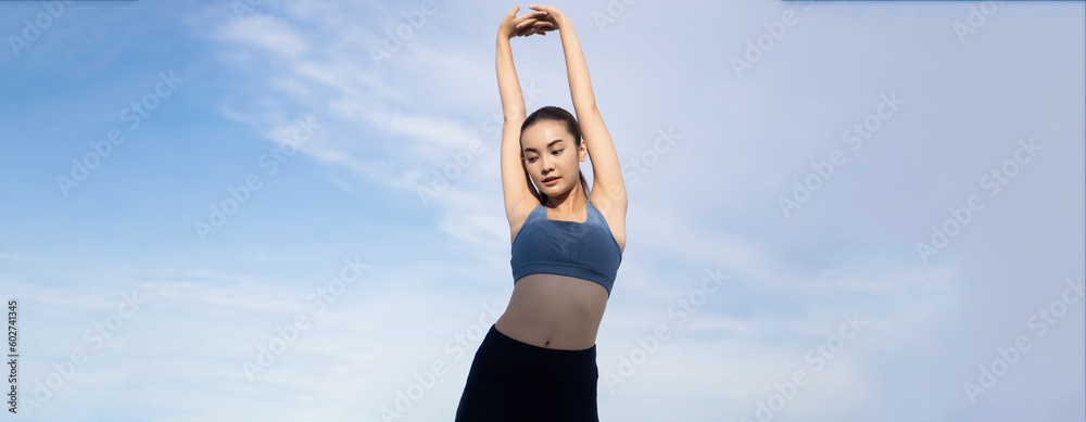 Young beauty Asian woman stretching workout outdoor. She warming up with a blue sky background.