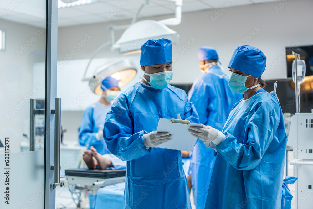 Professional doctors performing surgical operation in operating room.