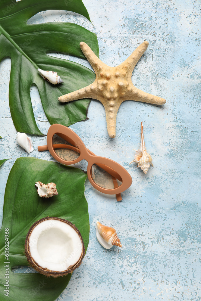 Composition with stylish sunglasses, palm leaves, coconut, starfish and seashells on color backgroun