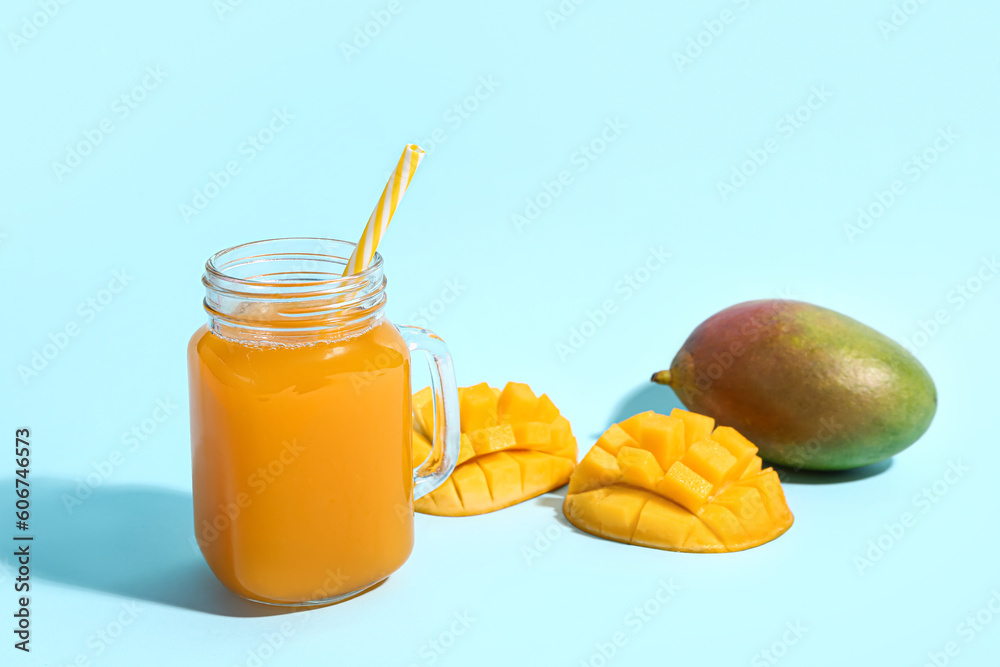 Mason jar of fresh mango smoothie on blue background