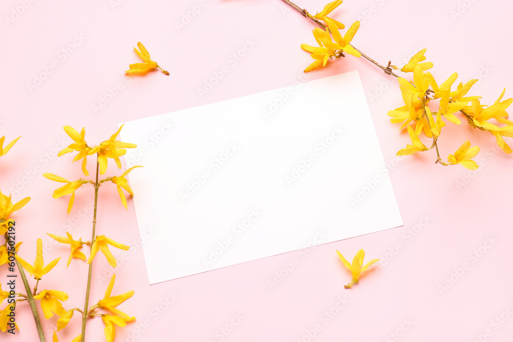 Blooming tree branches with yellow flowers and blank greeting card on pink background