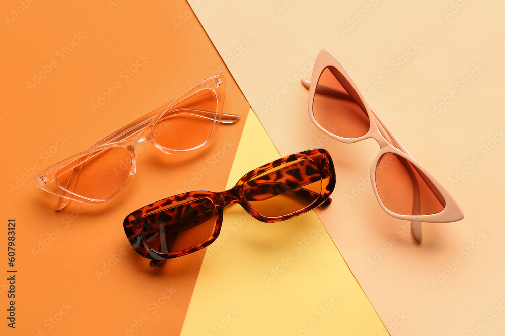 Stylish sunglasses on color background