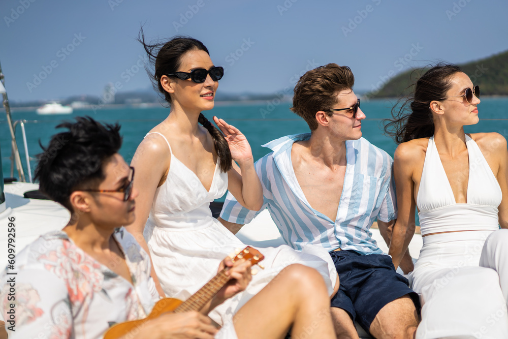 Group of diverse friend sit on deck of yacht while yachting together. 