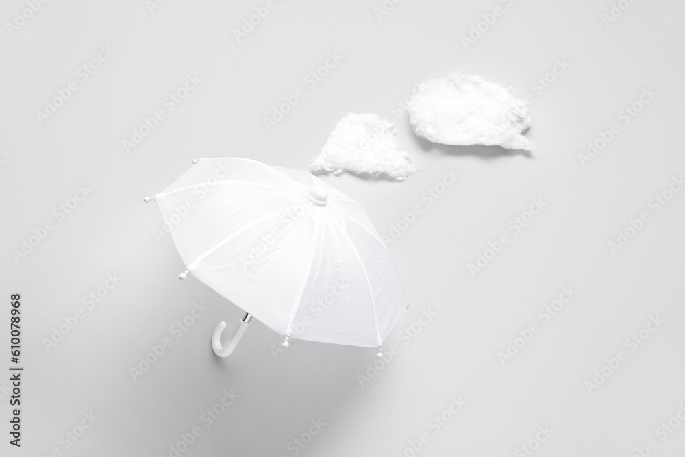 Composition with umbrella and clouds on white background