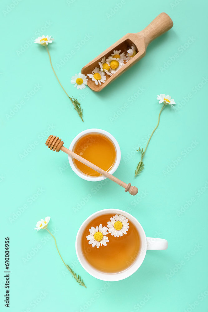 Cup of hot tea with honey and scoop on turquoise background