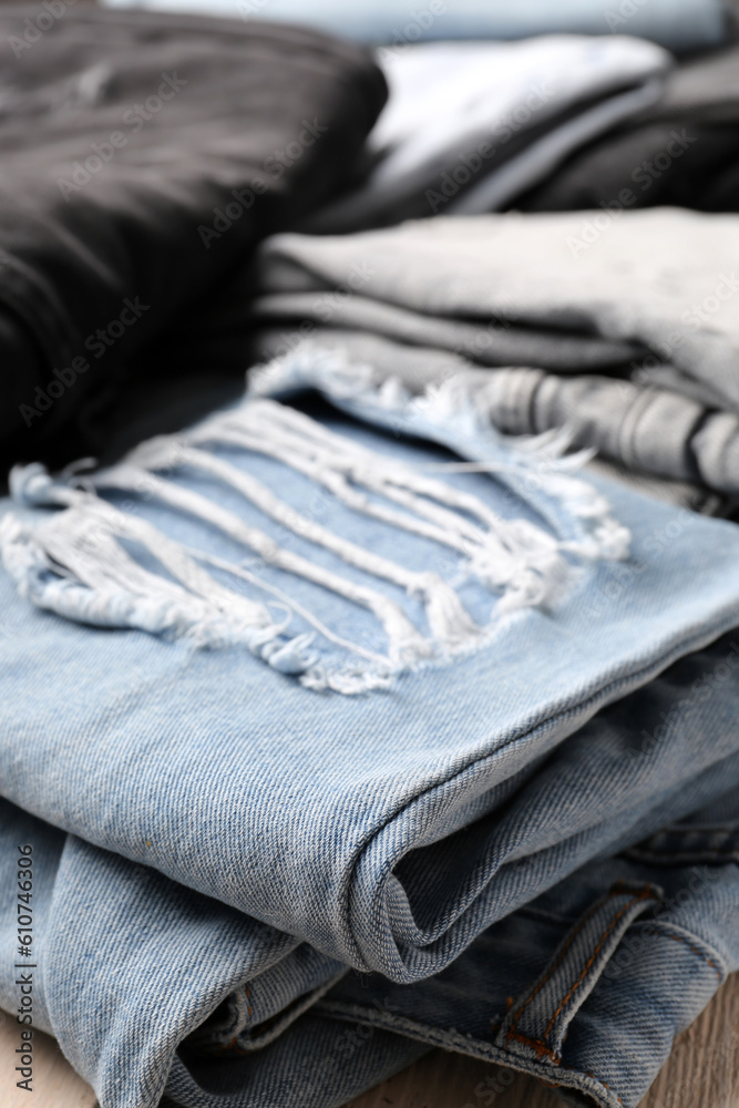 Different stylish denim jeans as background, closeup