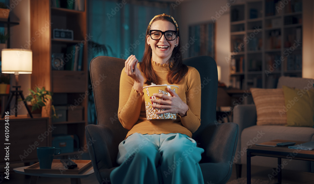 Expressive woman watching TV and eating popcorn