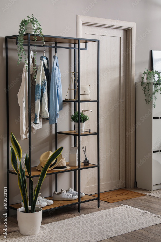 Shelving unit with clothes and accessories in modern hall