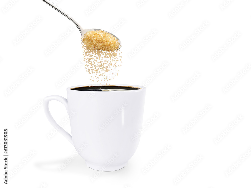 A spoonful of granulated sugar is poured into a white coffee mug. isolated on white background