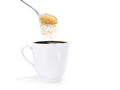 A spoonful of granulated sugar is poured into a white coffee mug. isolated  PNG transparent