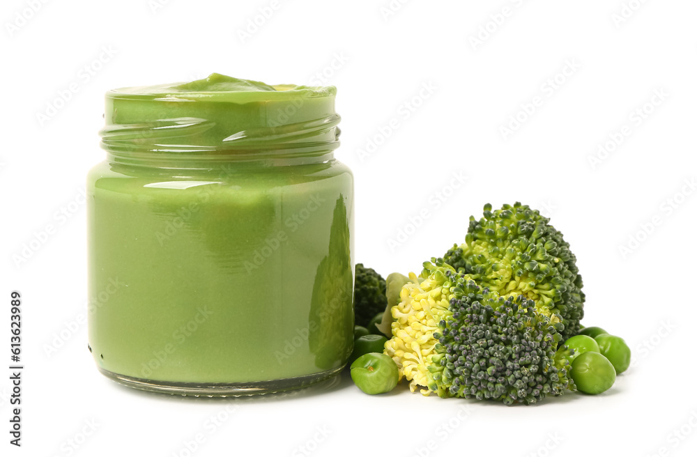Jar of baby food and vegetables on white background
