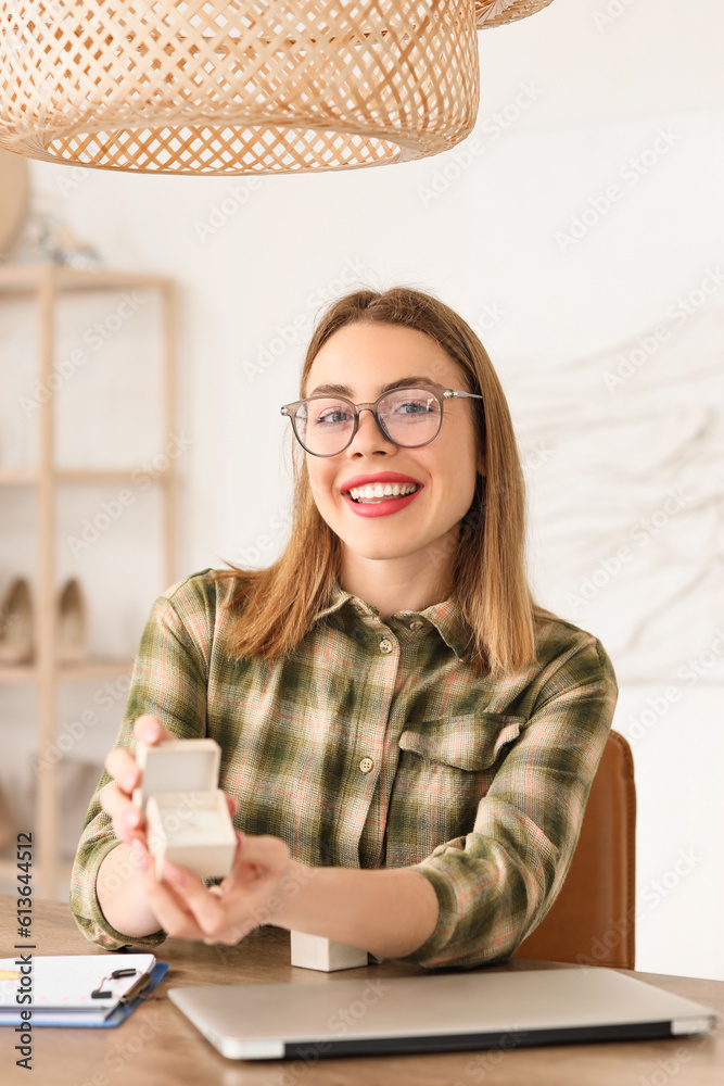 Female wedding planner with ring working at table in office