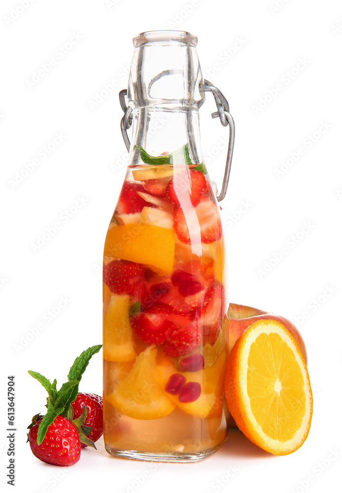 Bottle of infused water with different sliced fruits on white background