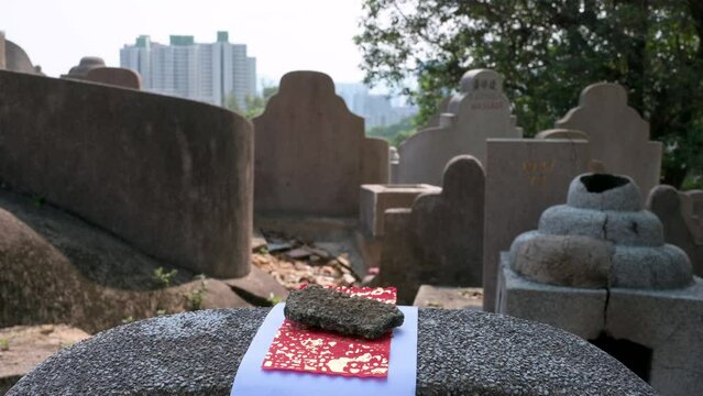 An offering lays on top of a tombstone at the Diamond Hill cemetery during the Chung Yeung Festival as citizens visit deceased relatives' graves and bring offerings in remembrance and respect.