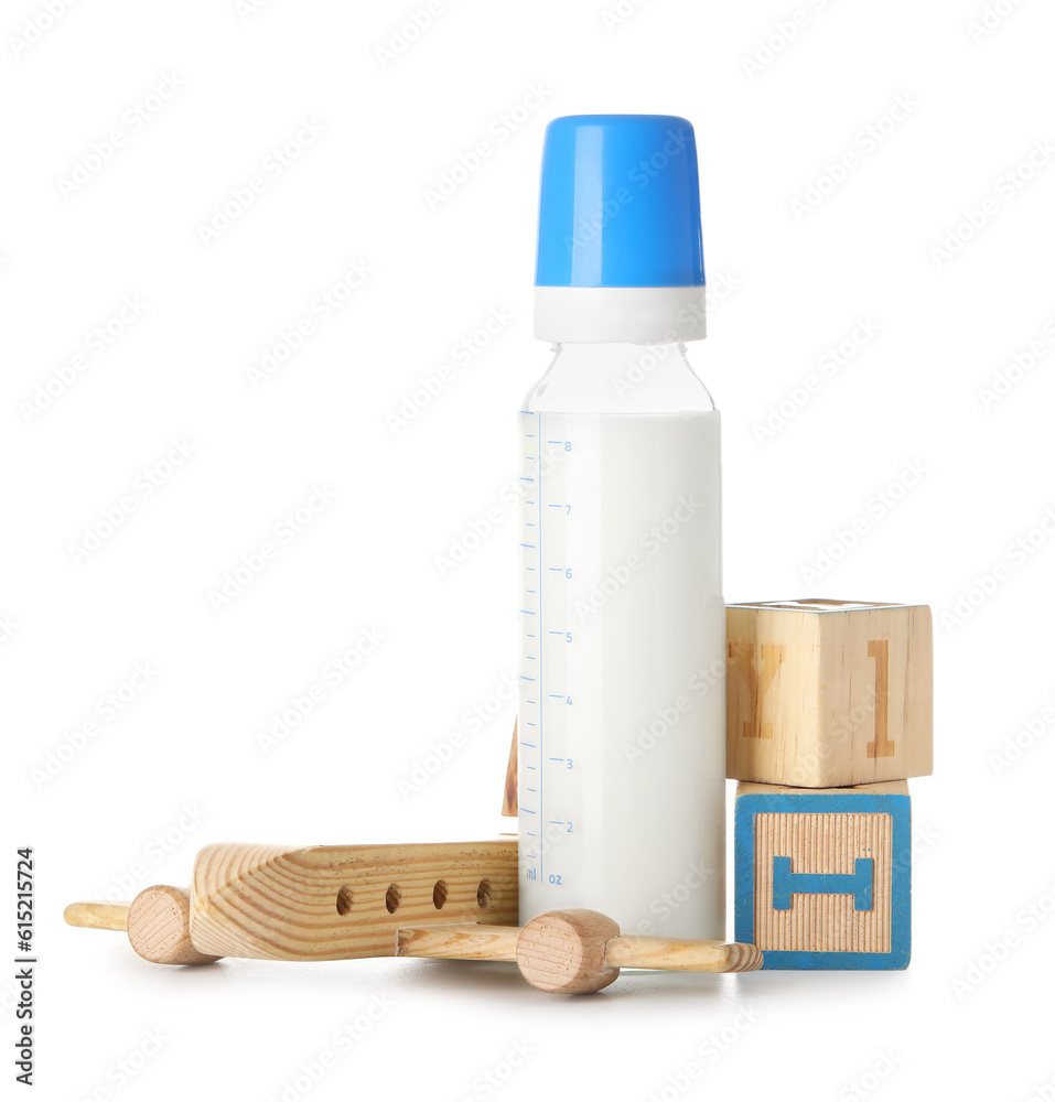 Bottle of milk for baby with toys isolated on white background