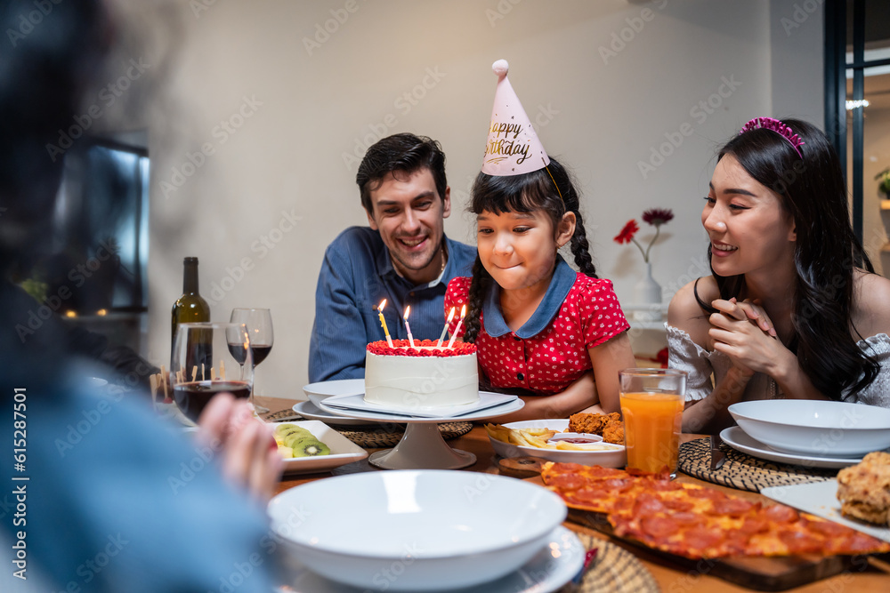 Multi-ethnic big family having a birthday party for young kid daughter.